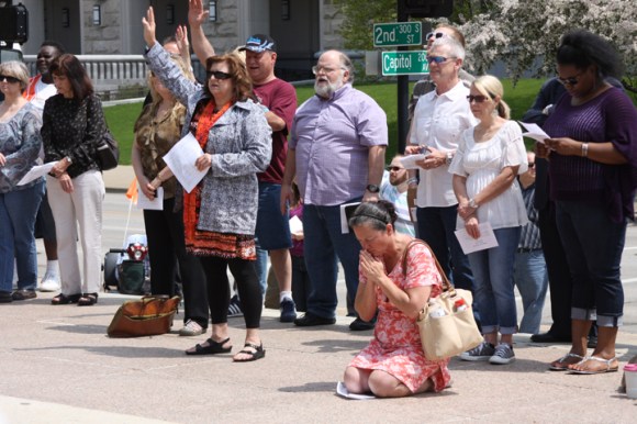 At a worship service on the National Day of Prayer, some knelt in prayer in front of the Illinois State Capitol, while others lifted their hands in worship.