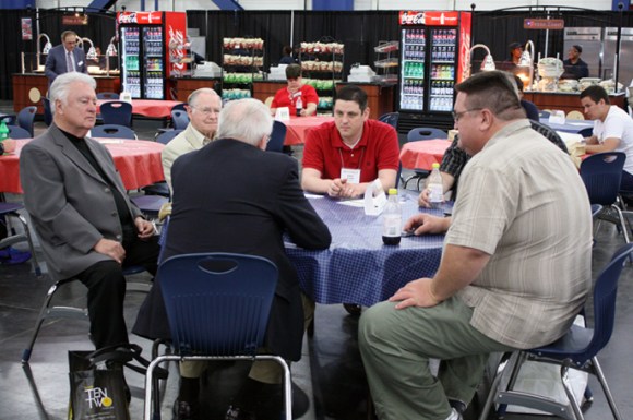 Illinois Baptist pastor Adam Cruse (center, in red) talked with friends in the exhibit hall, including Illinois' own Sons of the Father gospel group.