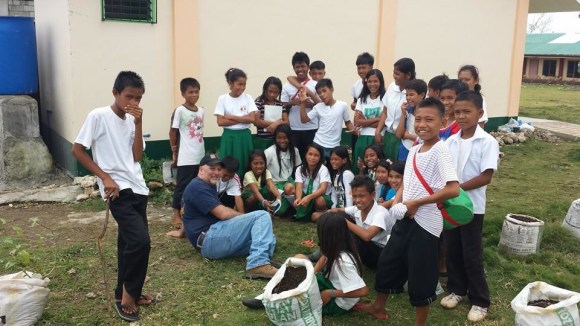 Kurt Crail, a volunteer from Ashmore Baptist Church, visits with school kids on Gibitngil Island in the Philippines.