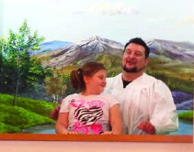 Pastor Brad Sloan baptizes his daughter, Delaney, at Dahlgren Baptist Church.