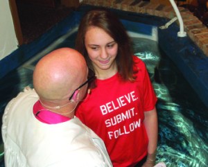 The shirt says it all -- Emily Zimmer is baptized by Pastor Tracy Smith at First Baptist Church in Mt. Zion.